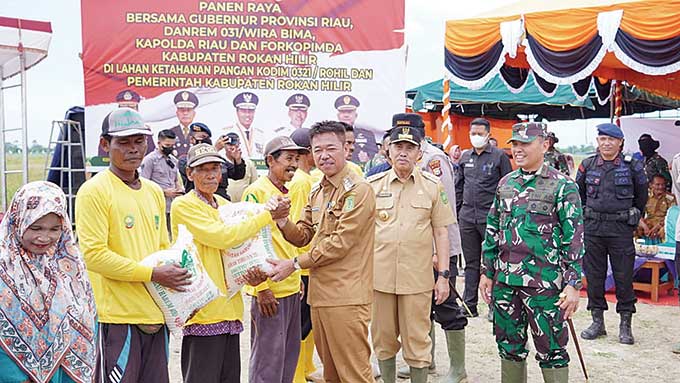 Bupati Rohil Afrizal Sintong SIP menyerahkan bantuan sembako di sela kegiatan panen padi di Rokan Baru Pesisir, Kecamatan Pekaitan, Senin (17/10/2022) kemarin.