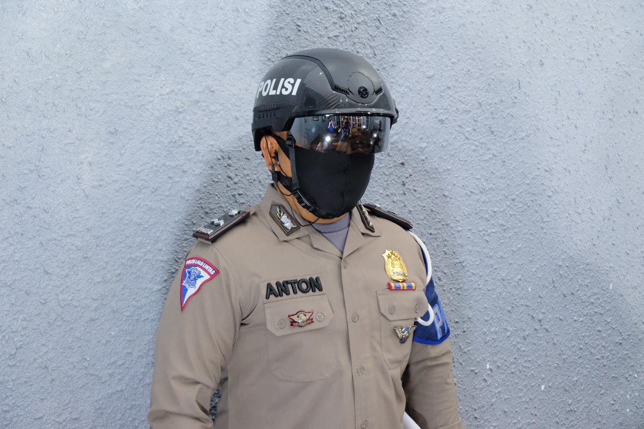 Salah seroang personil Polda Riau menggunakan Smart Helmed Thermal untuk mendeteksi secara dini warga yang terpapar Covid-19. (Bidang Humas Polda Riau untuk RIAUPOS.CO)