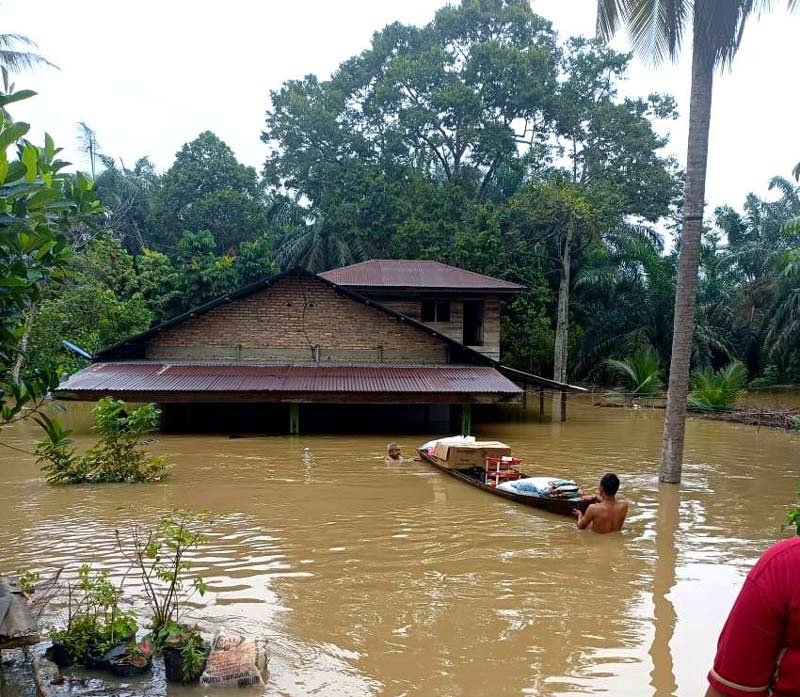Warga menggunakan perahu untuk menyelamatkan barang-barang setelah rumahnya di Dusun Pasir Pandak, Desa Kepenuhan Timur, Rokan Hulu direndam banjir, Jumat (29/12/2023).