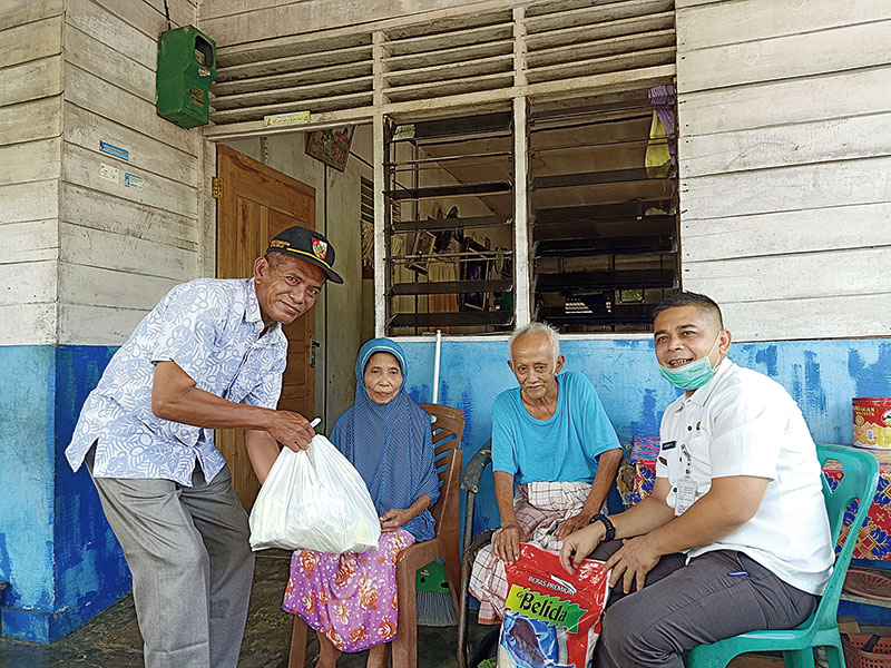 Lurah Sidomulyo Barat, Hendry Safitrah (kanan) dan Ketua RW setempat, Firdaus menyerahkan bantuan dari kelurahan untuk keluarga Baharudin, Rabu (29/4/2020).(*1/MIRSHAL/RIAU POS)