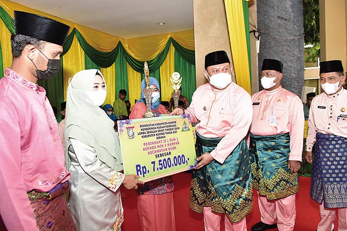Bupati Kampar HÂ  Catur Sugeng Susanto SH MH secara simbolis menyerahkan hadiah kepada pemenang perlombaan dalam rangka memeriahkan Hari Jadi ke-72 Kabupaten Kampar di halaman upacara Kantor Bupati Kampar, Ahad (6/2/2022).