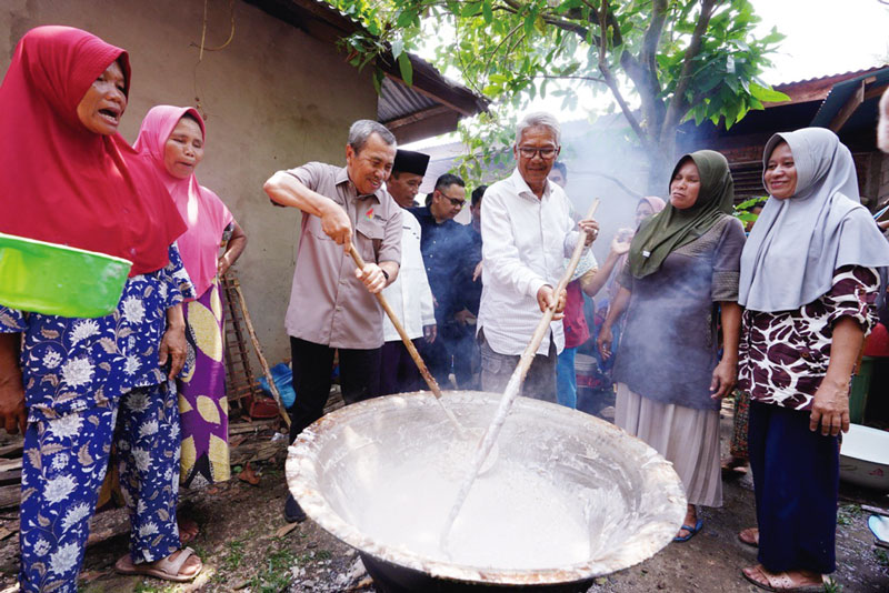 Gubri Drs H Syamsuar ikut mengaduk makanan khas Kuansing Konji Barayak di sela kunjungan ke kabupaten tersebut, Sabtu (2/9/2023).