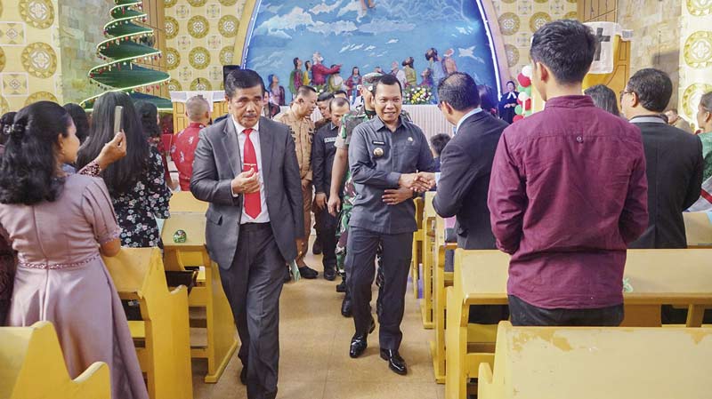 Pj Wali Kota Pekanbaru Muflihun bersama forkopimda menyalami jemaat saat kunjungan ke Gereja Huria Kristen Batak Protestan (HKBP) Maranatha Jalan Rawa Indah, Kecamatan Payung Sekaki Pekanbaru, Ahad (24/12/2023).