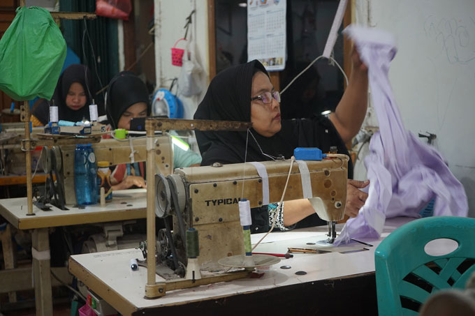 Pekerja menjahit pakaian seragam sekolah di usaha konveksi, Jalan Delima 7, Senin (3/7/2023). Jelang tahun ajaran baru, usaha pakaian seragam sekolah mulai kebanjiran pesanan. Harga seragam per stelnya berkisar Rp155 ribu hingga Rp165 ribu.