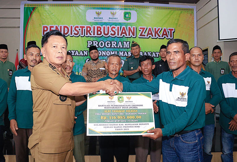 Plt Bupati Kepulauan Meranti H Asmar secara simbolis menyerahkan bantuan kepada salah seorang keluarga penerima manfaat di Selatpanjang, Rabu(18/10/2023).