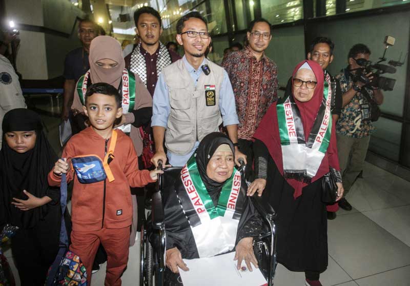 Muhammad Husein (tengah) mendorong kursi roda ibunya di Terminal 3, Bandara Soekarno-Hatta, Tangerang, Rabu (15/11/2023). Husein merupakan WNI dan menikah dengan warga Palestina terpaksa pulang ke Indonesia setelah daerah mereka digempur oleh Israel.