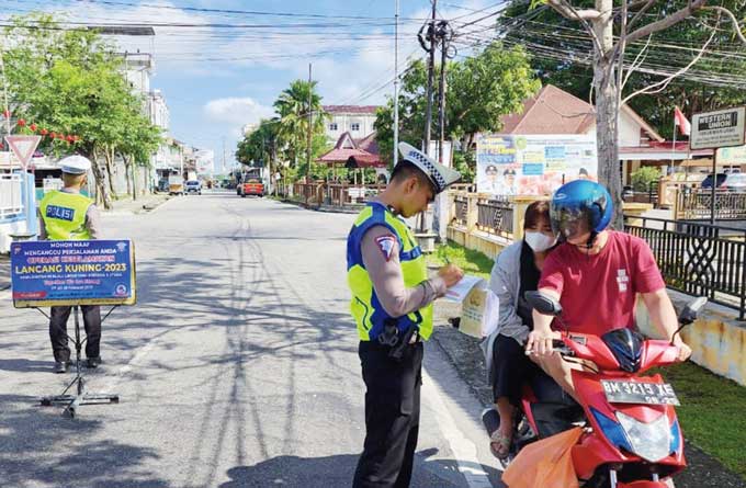 Petugas sedang memberikan teguran tertulis kepada pengendara tergolong abai terhadap aturan yang berlaku, Sabtu (11/2/2023).