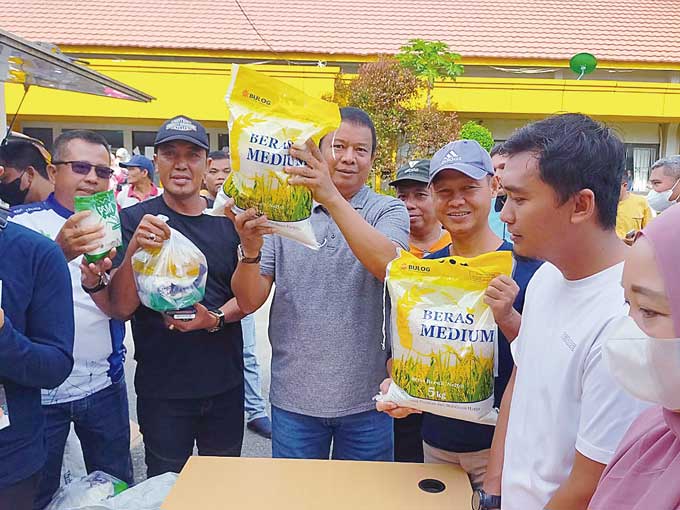 Sekdakab Inhu Ir H Hendrizal MSi (empat kanan) bersama pejabat di lingkungan Pemkab Inhu memperlihatkan jenis bahan pokok yang dijual pada pelaksanaan pasar murah, Kamis (2/3/2023).