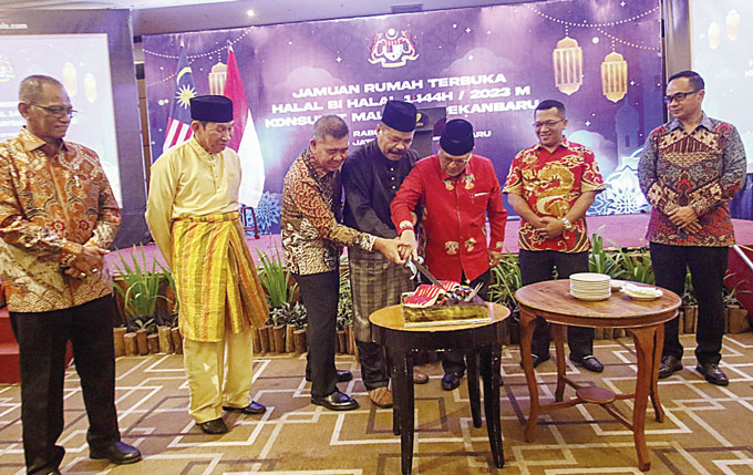 Wakil Konsulat Malaysia Pekanbaru Awaluddin Mohd Nasir (tengah) bersama Asisten III Setdaprov Riau Joni Irwan (tiga kanan) disaksikan sejumlah undangan memotong kue saat acara halalbihalal Konsulat Malaysia  di  Pekanbaru, Kamis (18/5/2023).