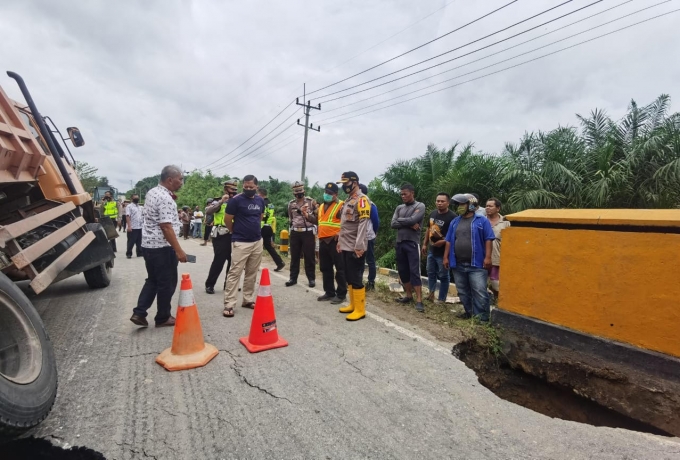 Personil Satlantas Polres Pelalawan melakukan pengalihan aktivitas kendaraan roda dua dan roda empat di Jalan Lintas Timur KM 55 akibat adanya jembatan amblas, Sabtu (19/9/2020).(M AMIN AMRAN/RIAUPOS.CO)