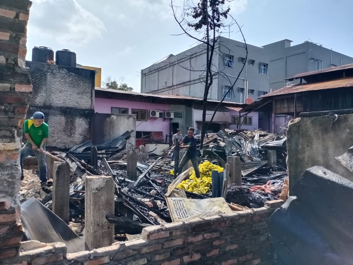 Para karyawan Rumah Makan Angkringan Asam Pedas Baung, di Jalan Jenderal Sudirman, sedang mangais puing-puing kebakaran di tempatnya bekerja. Selasa (4/2/2020). (SOFIAH/RIAUPOS.CO)