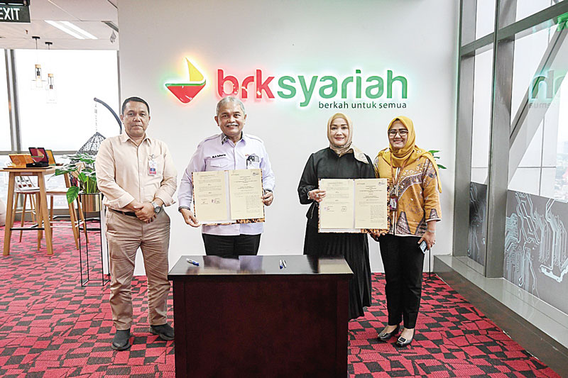 Direktur PT Dianra Kartika Nasir, Lucky Kartika Sari (dua kanan) dan Direktur Dana dan Jasa BRK Syariah MA Suharto (dua kiri) didampingi manajamen menunjukkan dokumen memorandum of understanding setelah ditandatangani, Selasa (5/9/2023).