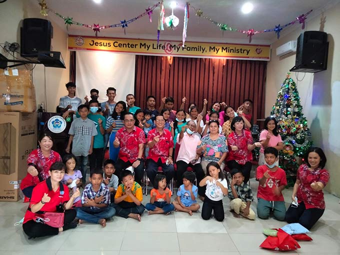 Anggota PSMTI Riau foto bersama dengan anak-anak panti asuhan di Kota Pekanbaru, Kamis (23/12/2021).