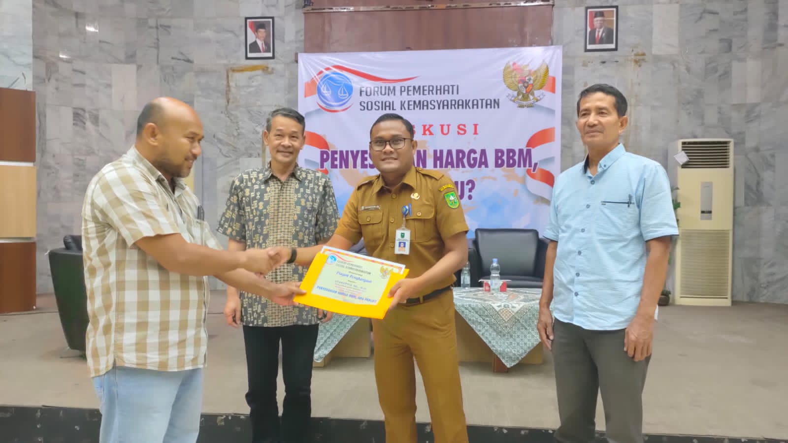 Ketua forum pemerhati sosial kemasyarakatan Amril menyerahkan piagam penghargaan kepada narasumber diskusi publik, Senin (26/9/2022).