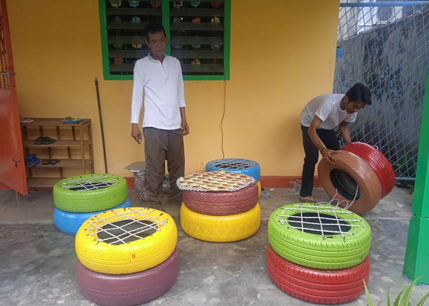 Azmi (kanan) bersama Ketua RT 03 Rw 04, Kelurahan Ladang Terubuk Bukhori Abdullah (kiri) saat mengerjakan produk daur ulang ban bekas untuk disulap menjadi kursi atau sofa dan juga meja, Sabtu (12/3/2022).