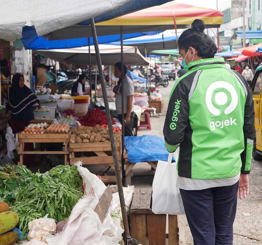 Salah seorang mitra Gojek berbelanja kebutuhan pokok yang dipesan warga melalui aplikasi GoShop di salah satu pasar tradisional Pasar Kodim, Pekanbaru baru-baru ini.(Gojek for RiauPos.co)