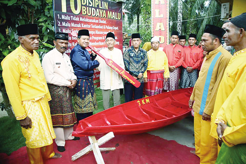 Sekda Rohul H Abdul Haris SSos MSi mewakili Bupati Rohul H Sukiman menyerahkan bantuan sampan kepada masyarakat saat menghadiri peringatan hari jadi ke-43 Desa Sungai Kumango, Kecamatan Tambusai, Jumat, (13/3/2020). (HUMAS PEMKAB ROHUL FOR RIAUPOS.CO)