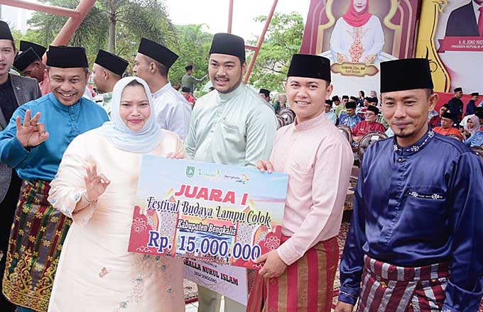 Bupati Bengkalis Kasmarni menyerahkan hadiah kepada pemenang lomba Festival Lampu Colok dan Pawai Takbir 2023 di Lapangan Tugu Bengkalis, Selasa (2/5/2023).