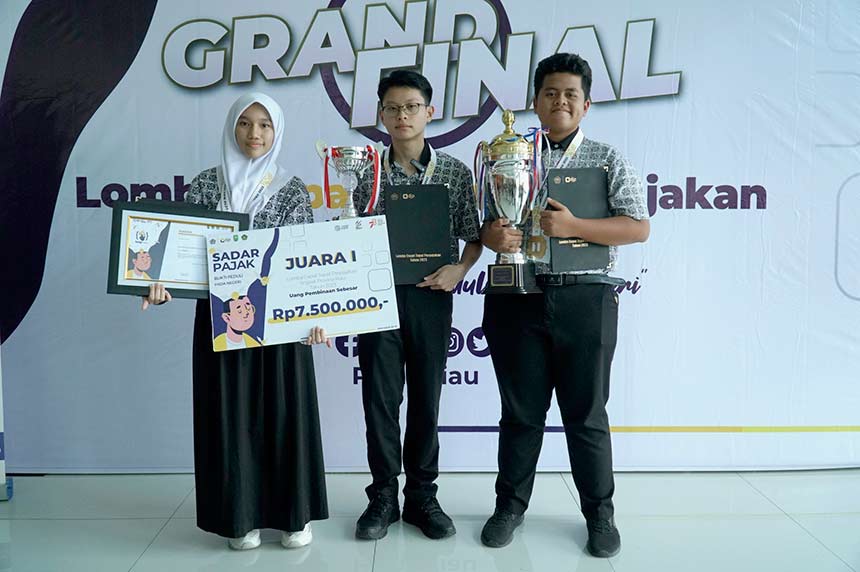 M Faiz Putra Sena, Evan Andrian, dan Jihan Madiha, siwa-siswi kelas 11 dari SMA Cendana Duri, memperlihatkan piala juara 1 Lomba Cepat Tanggap Perpajakan tingkat SMA/SMK sederajat Provinsi Riau, yang diadakan di Kampus Politeknik Caltex Riau, Sabtu (2/9/2