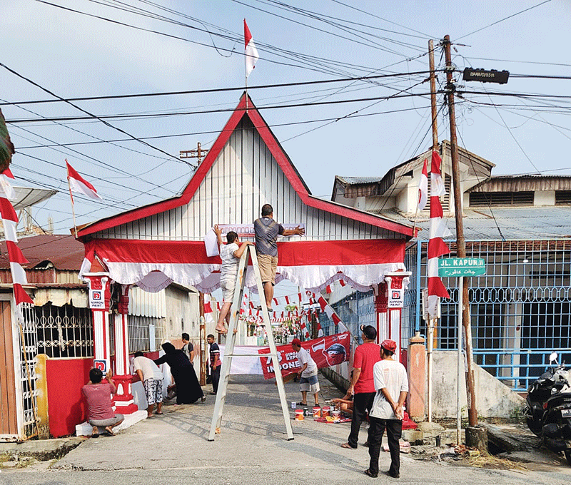 Warga RW 07 Kampung Baru, Senapelan bergotong roÂ­yong menghiasi gapura Kampung Merdeka untuk menyeÂ­marakÂ­kan HUT ke-78 Kemerdekaan RI, Ahad (13/8/2023).