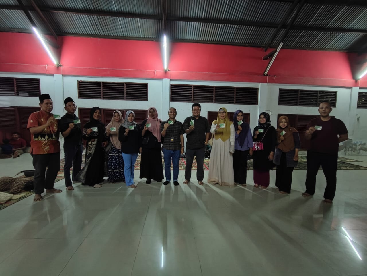 Pengurus dan anggota Ikatan Keluarga Pesisir Selatan (IKPS) Dumai memperlihatkan kartu keangotaan peserta BPJS Ketenagakerjaan usai dilakukan kerja sama, Selasa (18/7/2023).