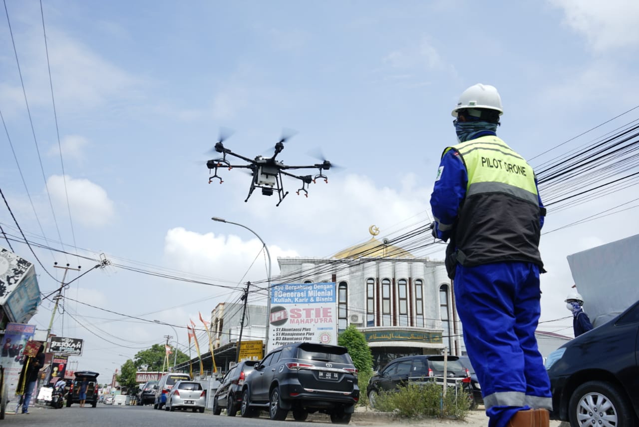 Penyemprotan caira disinfiktan menggunakan drone oleh Polda Riau di kawasan pemukiman penduduk Jalan Pangeran Hidayat, Pekanbaru, Rabu (25/3/2020).(MHD AKHWAN/RIAUPOS.CO)