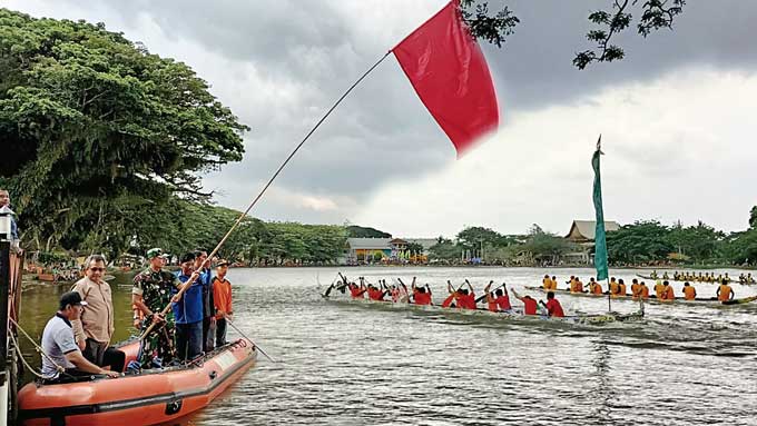 Dandim 0302/Inhu Letkol Kav Dani Prasetyo Wibowo SSos bersama Ketua PODSI Inhu Muhammad Ridwan disaksikan Staf Ahli Bidang Administrasi Umum Ahmad Syukur SSos MSi dan pejabat lainnya saat melepas pacu sampan mini di Danau Raja, Rengat, Jumat (30/9/2022).