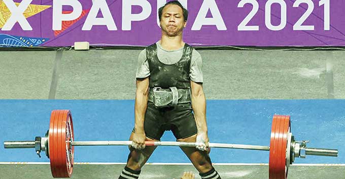 Lifter Riau Risky Syaifahmi meraih medali emas di kelas 59 kg angkat berat putra PON XX Papua di Auditorium Universitas Cenderawasih, Jayapura, Senin (11/10/2021). Foto kanan, perenang Riau Anandia Treciel Vanessae Evato meraih emas nomor 100 meter gaya d