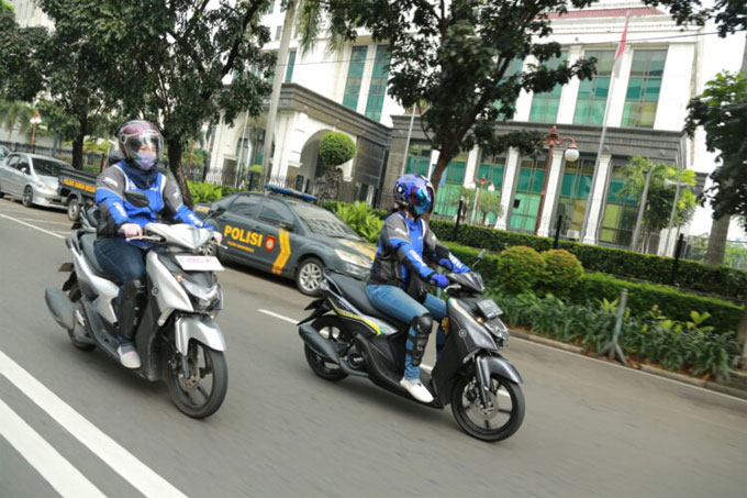 Ilustrasi mengendarai sepeda motor matik.