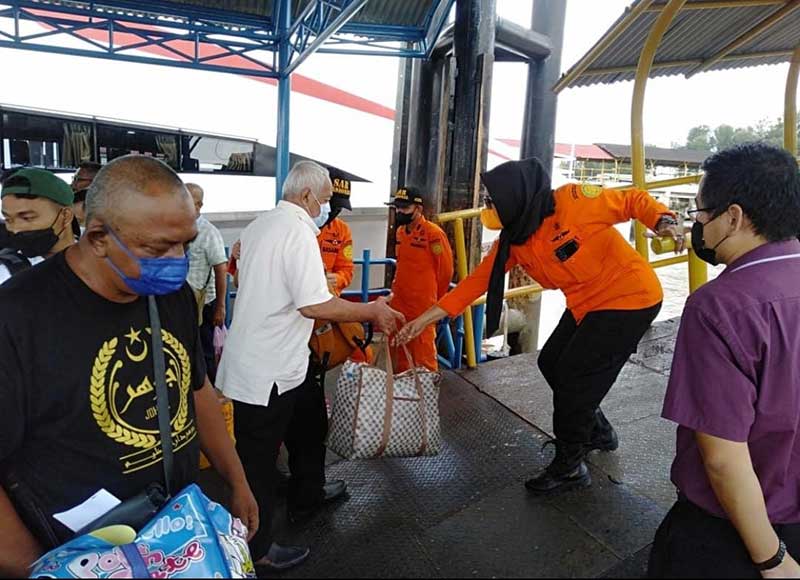 Seorang petugas membantu penumpang kapal penyeberangan Indonesia- Malaysia dengan rute Dumai- Melaka-Port Dickson  yang menggunakan jasa kapal penyeberangan cepat Indomal Fast Ferry di Pelabuhan Internasional Dumai, Jumat (6/5/2022).