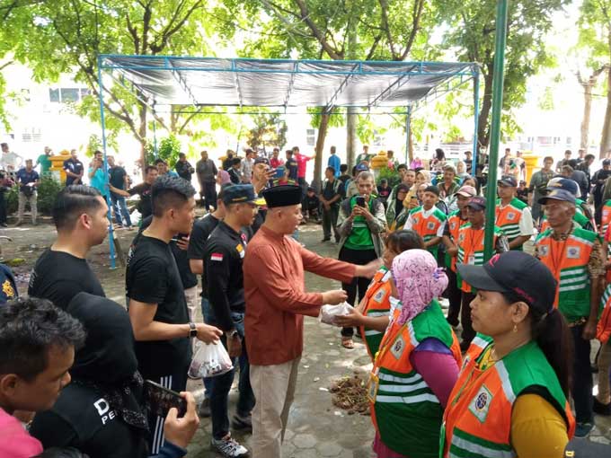 Sekretaris Kota (Sekko) Pekanbaru Indra Pomi Nasution secara simbolis menyerahkan daging kurban ke para jukir di momen Hari Raya Iduladha 1444 Hijriah di Kompleks Mal Pelayanan Publik (MPP) Pekanbaru, Ahad (2/7/2023).