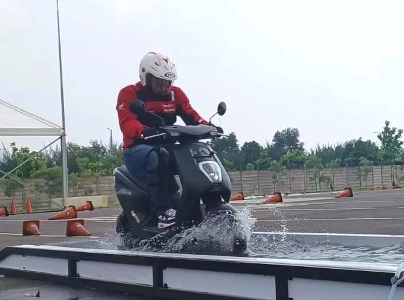 Sepeda motor listrik Honda EM1 e saat diuji melewati genangan air, baru-baru ini.