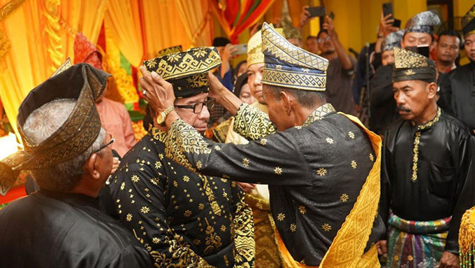 Ketua LAMR Siak Datuk Seri Wan Said memakaikan tanjak kepada Habib Dr Salim Segaf Al-Jufri dengan gelar Datuk Maulana Sukma Jaya di Gedung LAMR Siak, Ahad (6/11/2022).