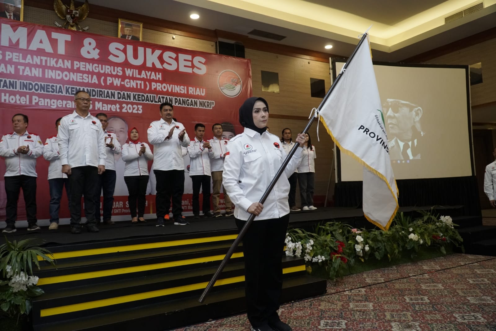 Ketua PW GNTI Riau Dewi Juliani SH mengibarkan pataka setelah secara resmi dilantik Ketua Umum PP GNTIÂ Prof Dr Ir Rokhimin Dahuri MS, Kamis (16/3/2023), di Ball Room Hotel Pangeran.
