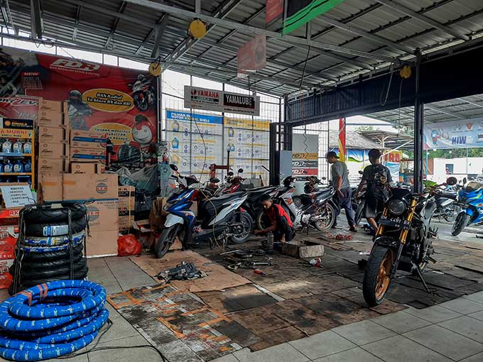 Mekanik saat melakukan servis motor di salah satu bengkel Jalan Jenderal Sudirman Pekanbaru, Selasa (26/4/2022). Permintaan perawatan motor mengalami peningkatan hingga 80 persen jelang Idulfitri 1443 Hijriah.