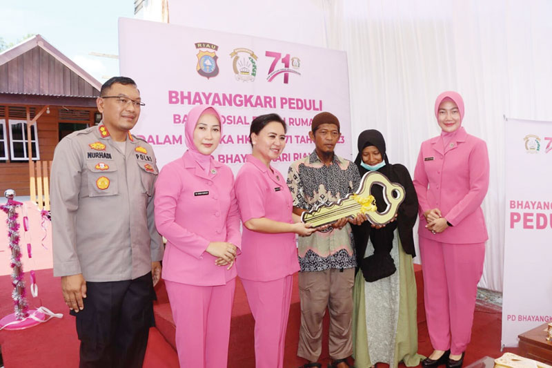 Ketua Bhayangkari Daerah Riau Nindya M Iqbal menyerahkan kunci rumah usai meresmikan rumah bantuan bedah rumah, dalam rangka Hari Kesatuan Gerak Bhayangkari (HKGB) ke-71 tahun 2023 di Jalan Rajawali, Dumai, Sabtu (8/7/2023).
