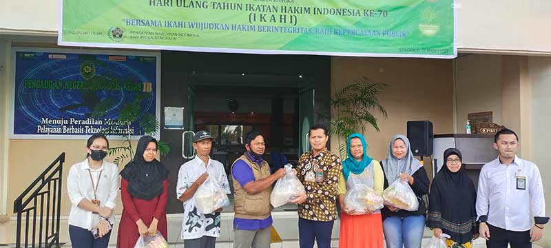 Ketua PN Bengkalis Bayu Soho Rahardjo menyerahkan sembako murah kepada warga kurang mampu di  Bengkalis di depan Kantor PN Bengkalis, Senin (20/3/2023).