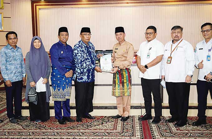 Kepala BPS Rohul Surya Legowo bersama 11 kepala OPD di lingkungan Pemkab Rohul menunjukkan MoU yang telah ditandatangani bersama di ruang aula Kantor Bappeda Rohul, Jumat (5/8/2022).