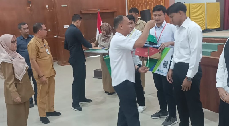Kepala BPJS Ketenagakerjaan Dumai Legi Handoko Pasaribu menyerahkan kartu peserta BPJS Ketenagakerjaan kepada peserta pelatihan, baru-baru ini.