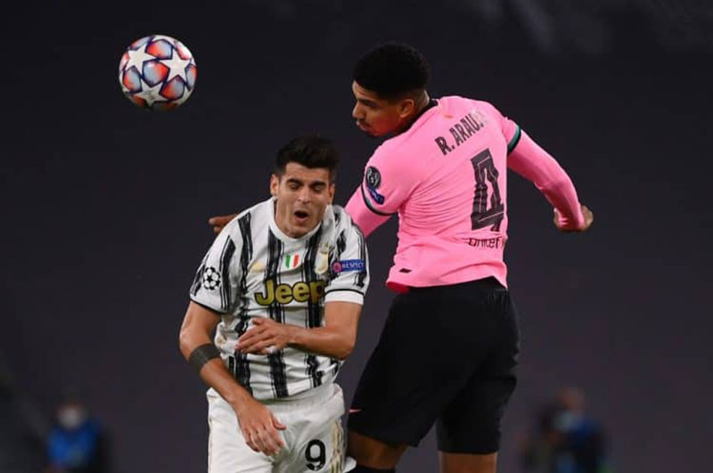 Bek Barcelona dari Uruguay Ronald Federico Araujo da Silva berduel dengan striker Juventus Alvaro Morata pada lanjutan laga grup G Liga Champions 2020-2021. (MARCO BERTOLELLO/AFP)
