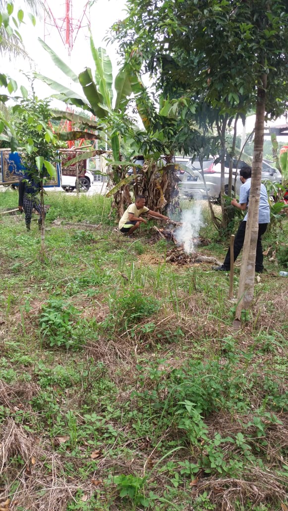 Sejumlah warga dan seorang petugas membakar spot tanah dan rumput di lokasi matinya anjing gila yang telah menggigit setidaknya 10 warga di Kecamatan Kampar hingga Senin (25/5/2020).(Dinas Kesehatan Kampar for RIAUPOS.CO)
