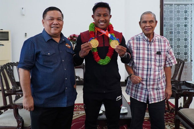 Atlet dayung Riau Maizir Riyondra (tengah) disambut Sekdaprov Riau SF Hariyanto (kiri), dan Ketua Umum KONI Riau Iskandar Hoesin (kanan) di VIP Lancang Kuning, Bandara SSK II Pekanbaru, Jumat (19/5/2023).