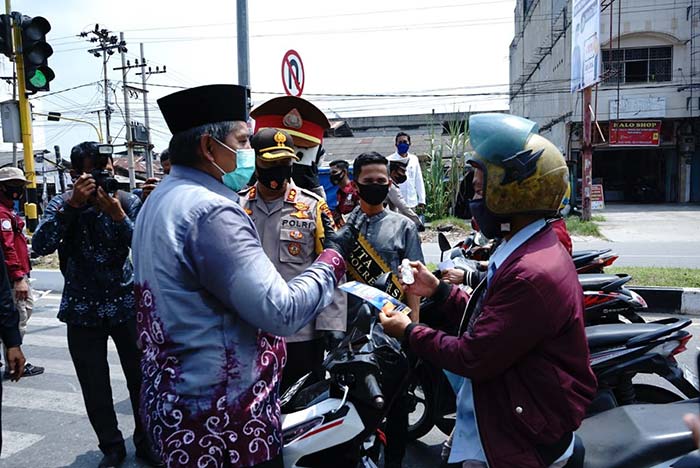 Bupati Siak Drs H Alfedri MSi didampingi Kapolres AKBP Doddy F Sanjaya membagikan handsanitizer kepada pengguna jalan di Perawang, akhir pekan lalu. DISKOMINFO SIAK