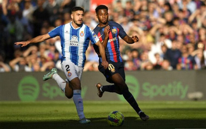 Penyerang Barcelona Ansu Fati (kanan) berduel memperebutkan bola dengan bek Espanyol Oscar Gil dalam pertandingan Liga Spanyol di Camp Nou, Barcelona pada 31 Desember.