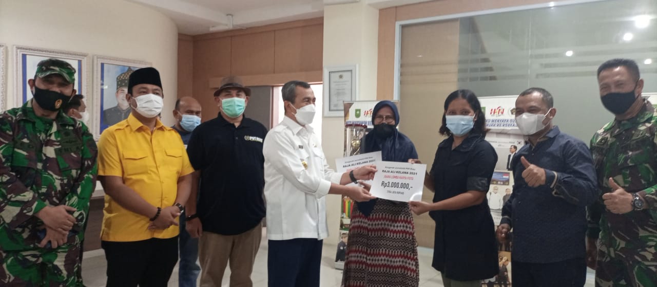Gubri Syamsuar menyerahkan hadiah kepada wartawan Riau Pos Henny Elyati sebagai salah satu pemenang LKTJ Ali Kelana 2021 didampingi Ketua PWI Riau H Zulmansyah Sekedang dan undangan lainnya disela acara penyembelihan hewan kurban di kantor PWI Riau Jalan