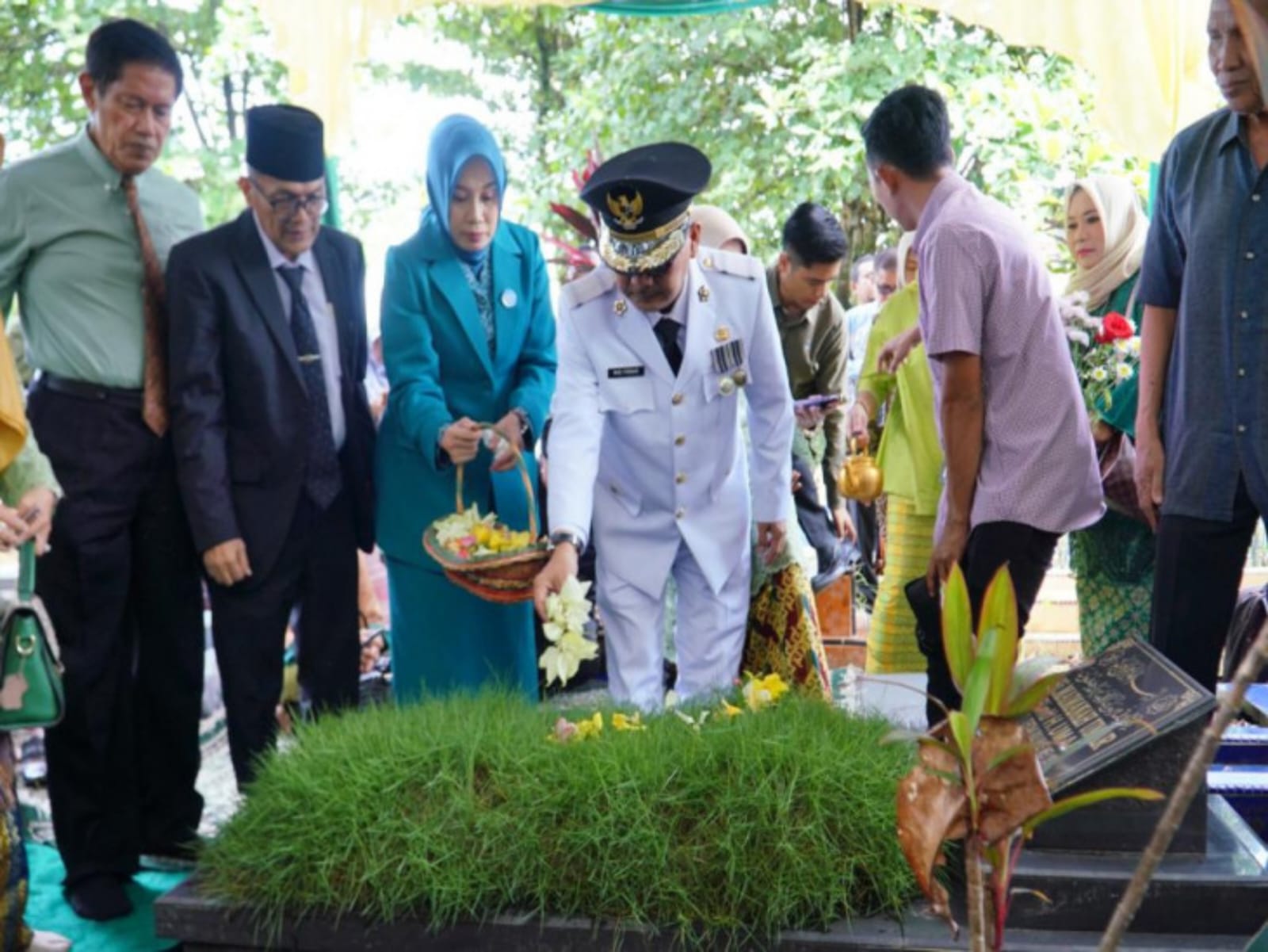 Pj Bupati Bupati Kampar Muhammad Firdaus bersama istri Ny Yusi Prastiningsih saat berziarah ke makam orang tuanya di pemakaman Kubang, Kecamatan Siak Hulu, Selasa (23/5/2023).