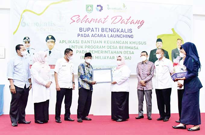 Bupati Bengkalis Kasmarni menyerahkan penghargaan kepada tokoh inspiratif pendidikan Sujarno di aula Polbeng, Rabu (18/5/2022).