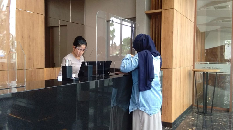 Karyawan Prime Park Hotel saat melayani tamu yang datang, Selasa (14/7/2020).(MUJAWAROH ANNAFI/RIAUPOS.CO)