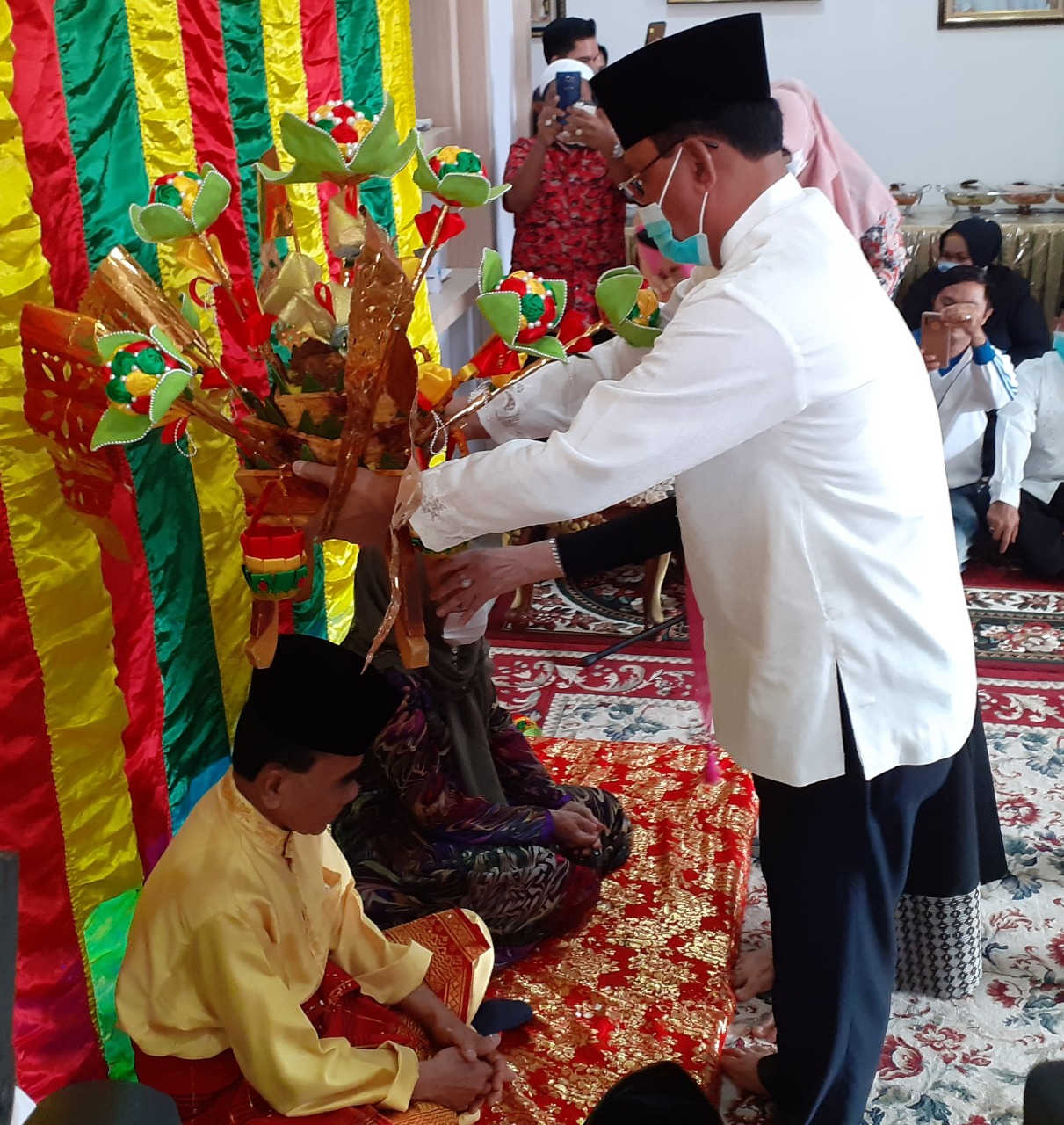 Tokoh masyarakat Rokan Hilir Suyatno AMp melangsungkan prosesi upah-upah menyambut kunjungan Annas Maamun di Bagansiapiapi, Jumat (2/10/2020).(ZULFADHLI/RIAUPOS.CO)