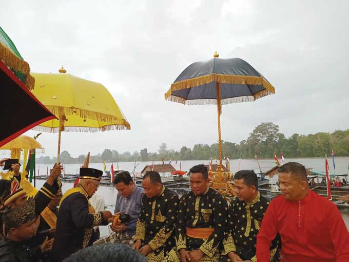 Sultan Pelalawan Assyaidis Syarif Kamaruddin Haroen melakukan penyiraman air kepada Bupati Pelalawan H Zukri dan Forkopimda Pelalawan dalam pelaksanaan prosesi mandi balimau Sultan di pinggir Sungai Kampar, dekat Istana Sayap Kerajaan Pelalawan, Ahad (12/